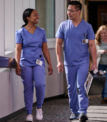 Healthcare workers walking in the hallway with a POUCS system.@2x